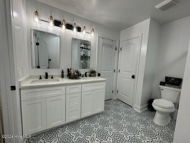 bathroom featuring tile patterned flooring, vanity, and toilet