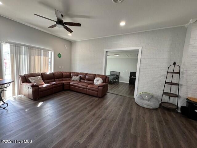 living room with ceiling fan, brick wall, and dark hardwood / wood-style floors