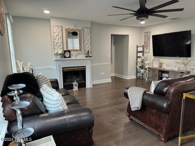 living room with dark hardwood / wood-style flooring, a wealth of natural light, and ceiling fan