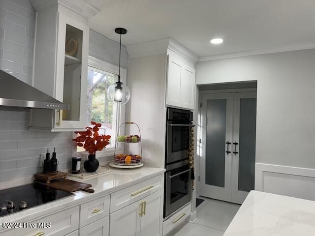 kitchen with white cabinetry, black appliances, and wall chimney range hood