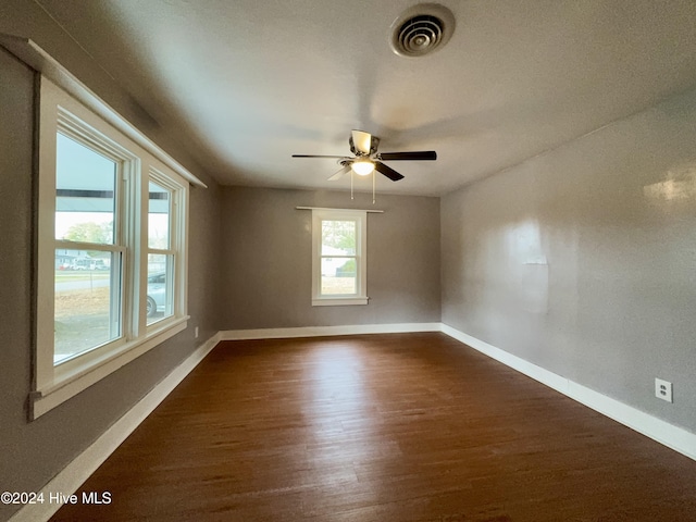 empty room with dark hardwood / wood-style floors and ceiling fan