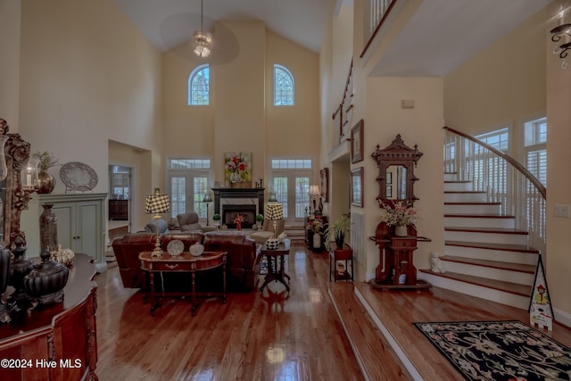 living area with a healthy amount of sunlight, a fireplace, stairway, and wood finished floors