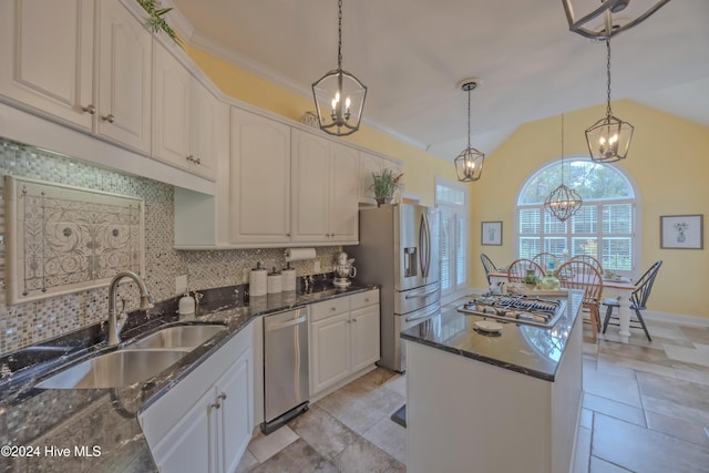 kitchen with appliances with stainless steel finishes, a chandelier, a sink, and decorative backsplash