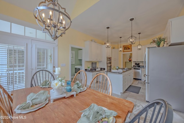 dining space with a chandelier and washer / dryer