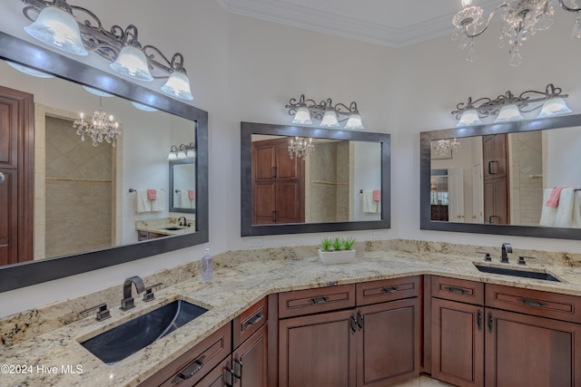 bathroom featuring a chandelier, double vanity, a sink, and crown molding