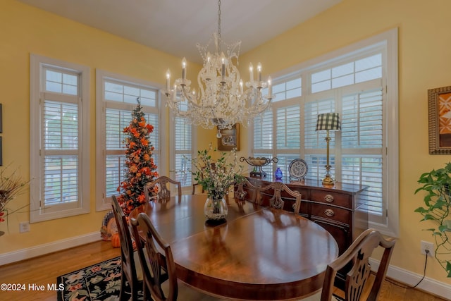 dining area featuring a notable chandelier, baseboards, and wood finished floors