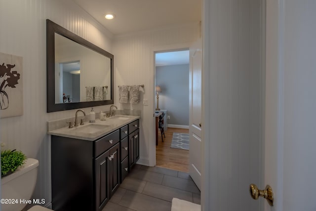 full bath featuring tile patterned floors, a sink, toilet, and double vanity