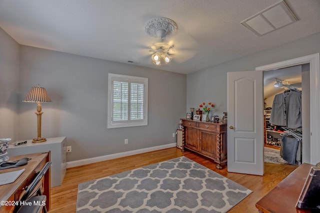 bedroom featuring a ceiling fan, light wood-type flooring, visible vents, and baseboards