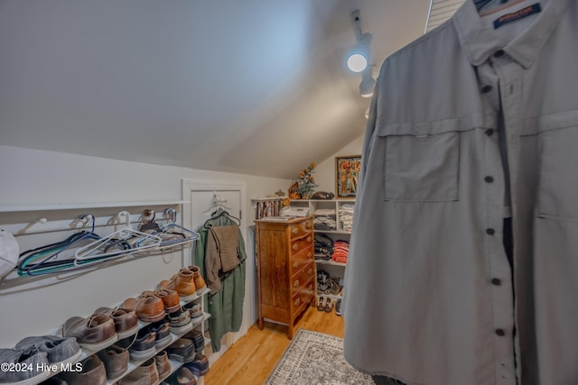 walk in closet featuring vaulted ceiling and light wood-type flooring