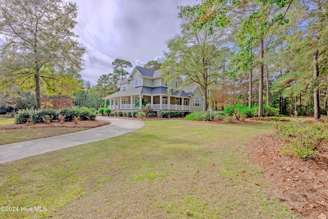 country-style home with covered porch, driveway, and a front lawn