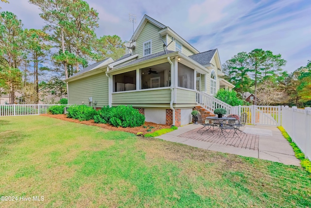 rear view of property with a patio, a lawn, a ceiling fan, a sunroom, and a fenced backyard