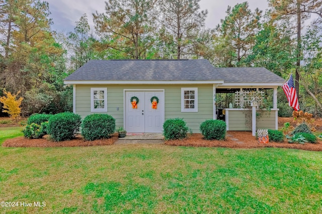 ranch-style house with roof with shingles and a front yard