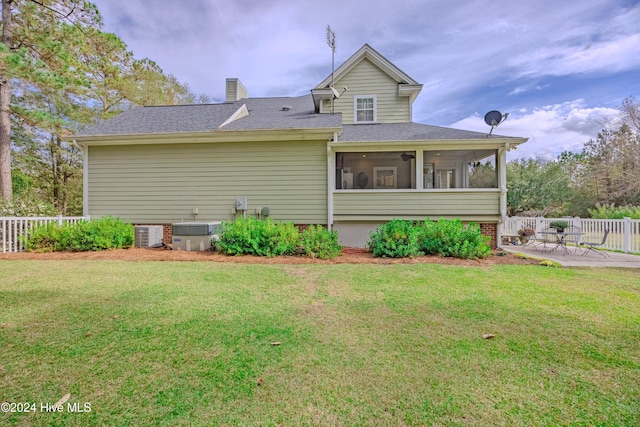 back of house with a lawn, a patio area, fence, and a sunroom