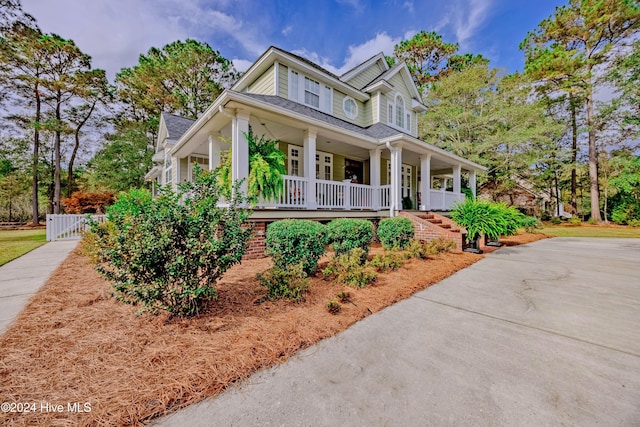 farmhouse inspired home with a porch and concrete driveway