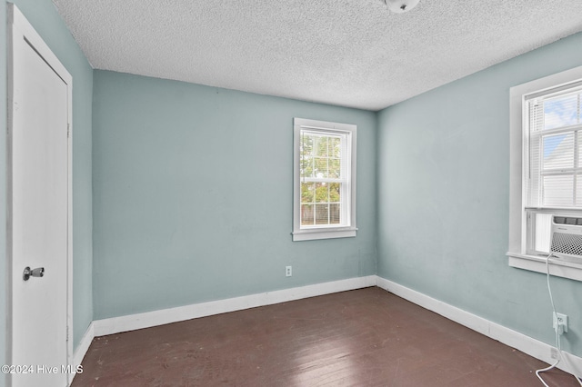 spare room with baseboards and a textured ceiling