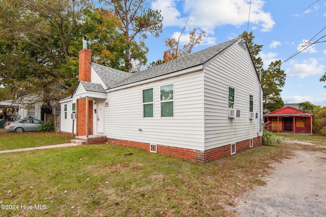 bungalow with a front yard, cooling unit, roof with shingles, a chimney, and dirt driveway