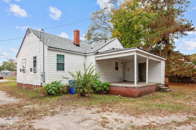 back of house with a chimney, fence, a patio, and roof with shingles