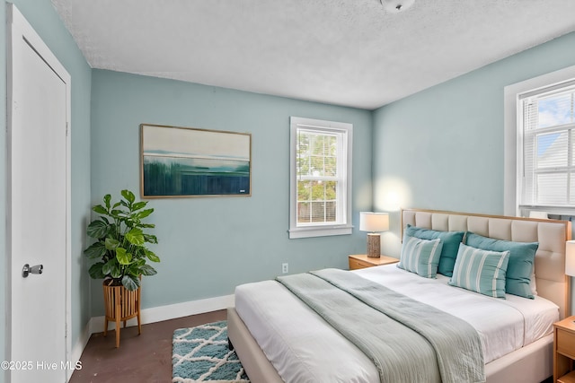 bedroom with baseboards and a textured ceiling