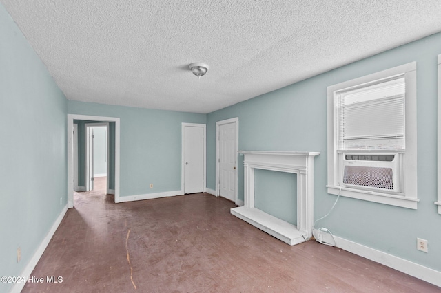 unfurnished living room featuring a textured ceiling, concrete flooring, and baseboards