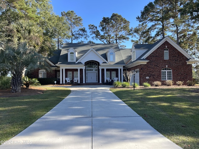 202 Jones Byrd Ct, Sunset Beach, NC 28468 - view of front of home featuring driveway, a front lawn, and brick siding