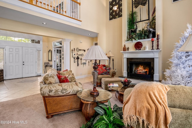 tiled living room featuring a high ceiling and decorative columns