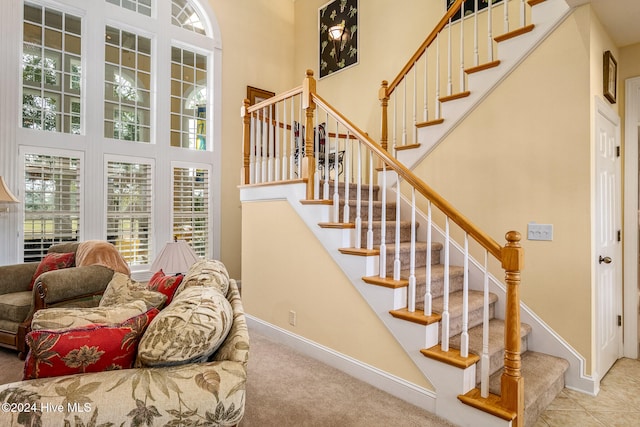 stairs with carpet flooring and a high ceiling