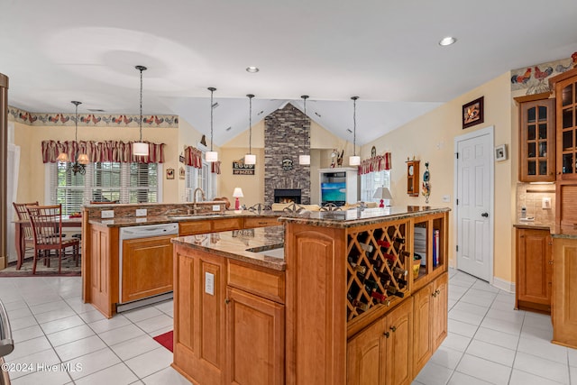 kitchen with kitchen peninsula, dishwashing machine, a kitchen island, and lofted ceiling