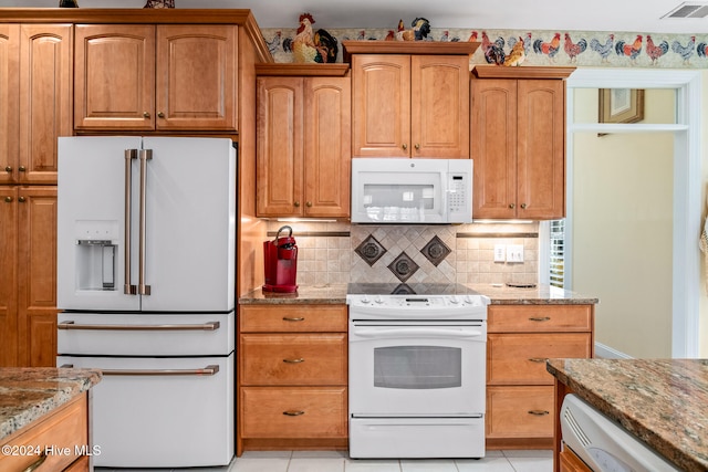 kitchen with white appliances, light tile patterned floors, and light stone counters