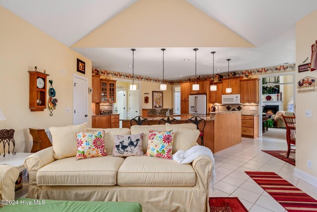 202 Jones Byrd Ct, Sunset Beach, NC 28468 - living area with light tile patterned flooring, lofted ceiling, and a lit fireplace