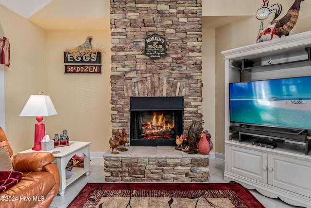 tiled living room with a stone fireplace