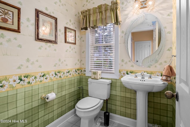 202 Jones Byrd Ct, Sunset Beach, NC 28468 - half bathroom featuring wallpapered walls, toilet, tile patterned flooring, plenty of natural light, and a wainscoted wall