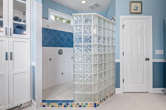 bathroom featuring tile patterned flooring and a tile shower