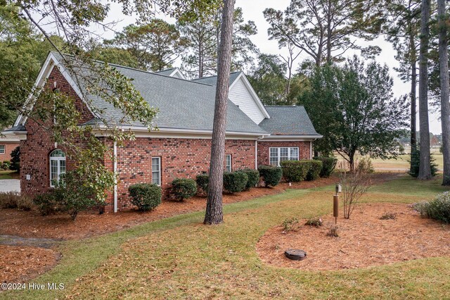 202 Jones Byrd Ct, Sunset Beach, NC 28468 - view of side of property featuring a yard, brick siding, and a shingled roof