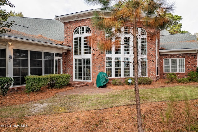 rear view of property with a sunroom and a yard