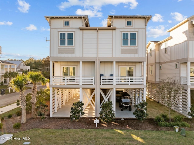 rear view of property with stairway, board and batten siding, and a patio