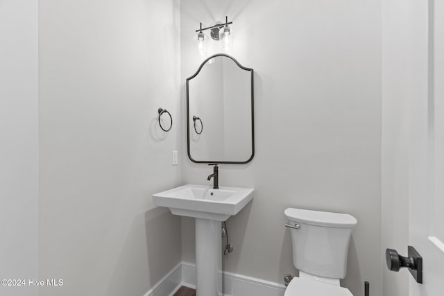 bathroom with toilet and baseboards