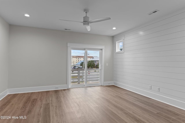 spare room with a ceiling fan, baseboards, visible vents, and wood finished floors