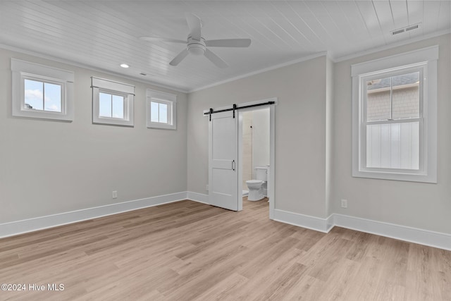908 Second St S Unit 2, Carolina Beach, NC 28428 - unfurnished bedroom featuring a barn door, light wood-style floors, baseboards, crown molding, and ensuite bath