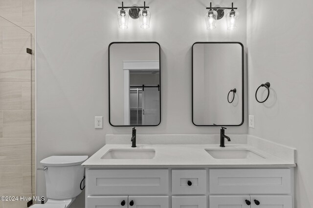 908 Second St S Unit 2, Carolina Beach, NC 28428 - bathroom with double vanity, toilet, and tiled shower