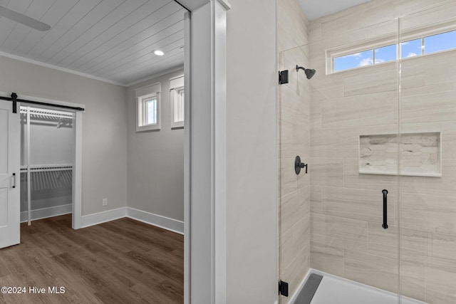 full bath featuring a stall shower, wood finished floors, a wealth of natural light, and baseboards