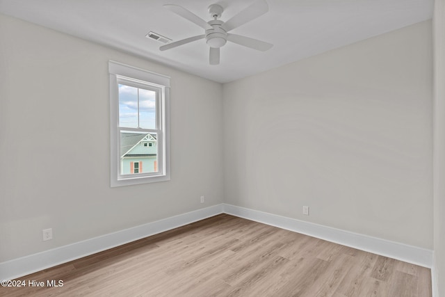 empty room with a ceiling fan, light wood-style flooring, visible vents, and baseboards