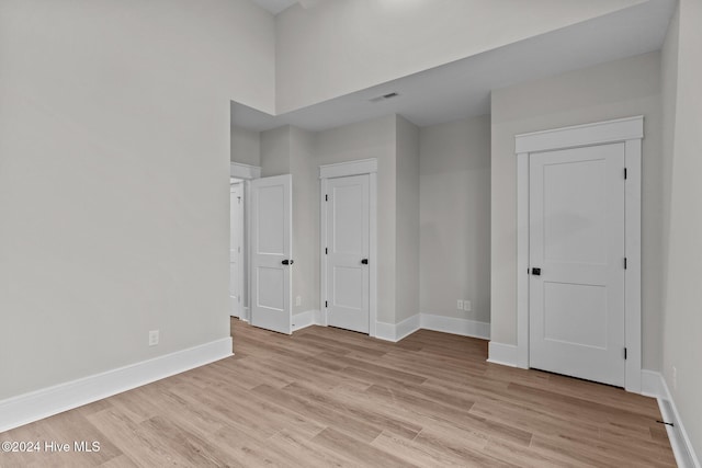 unfurnished bedroom featuring light wood-type flooring, visible vents, and baseboards