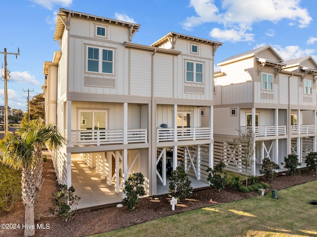 rear view of property featuring board and batten siding and a patio