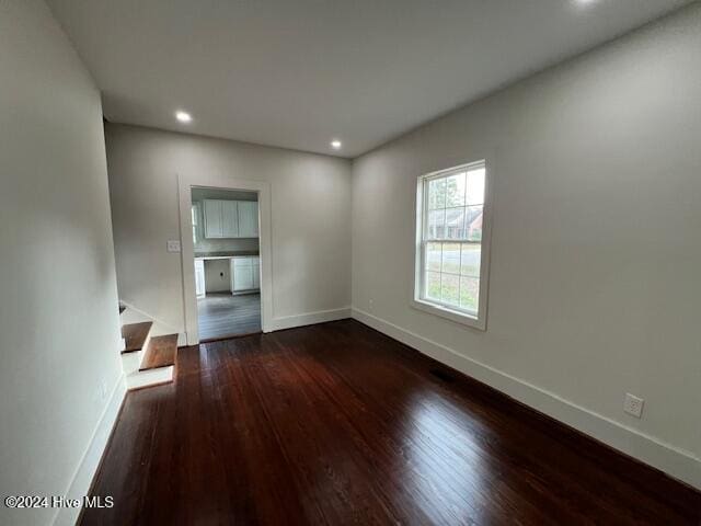 spare room with dark wood-type flooring