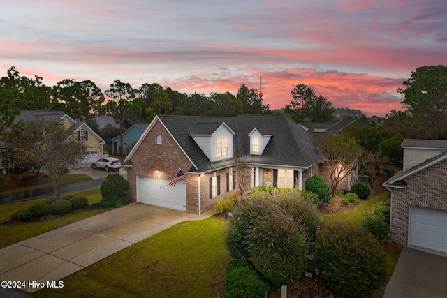 cape cod house featuring a lawn