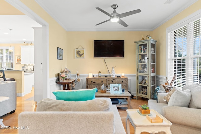 4151 Windham Ln, Southport, NC 28461 - living area featuring light wood-style flooring, ornamental molding, ceiling fan, a wainscoted wall, and a decorative wall
