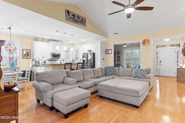4151 Windham Ln, Southport, NC 28461 - living room with a ceiling fan, light wood-style floors, lofted ceiling, and a chandelier
