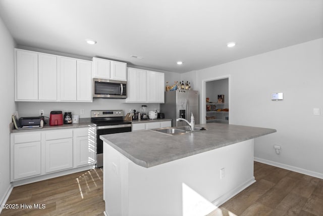 kitchen featuring appliances with stainless steel finishes, a center island with sink, white cabinetry, and sink