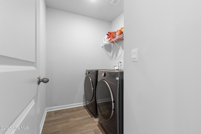 clothes washing area featuring independent washer and dryer and wood-type flooring