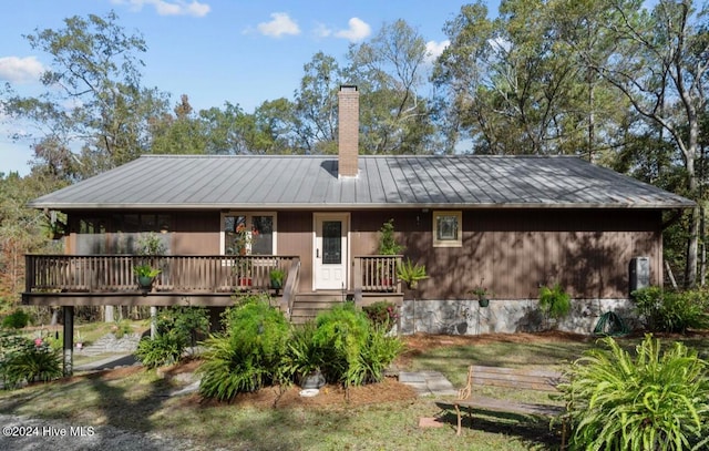 rear view of house featuring a wooden deck